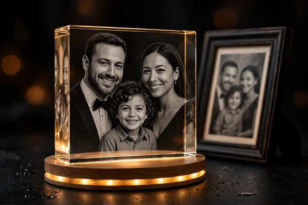 3D laser-engraved crystal portrait glowing on LED base next to a framed photo — AB Crystal Collection